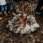 feu de camp avec des jambes autour